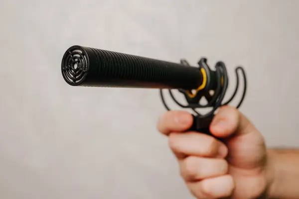 Une main tenant un micro canon